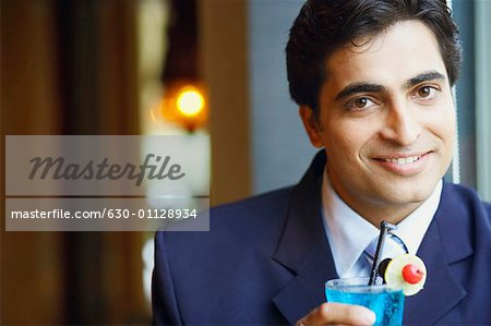 Portrait d'un homme d'affaires tenant un verre de cocktail