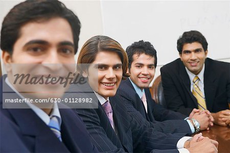 Portrait of four businessmen sitting in a conference room