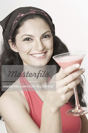 Portrait d'une jeune femme tenant un verre de martini