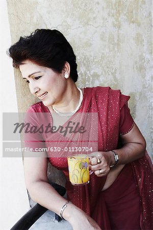 Mature woman holding a tea cup and looking down