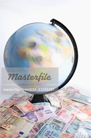 High angle view of a globe on a heap of Indian banknotes and Euro banknotes High angle view of a globe on a heap of Indian banknotes and Euro banknotes