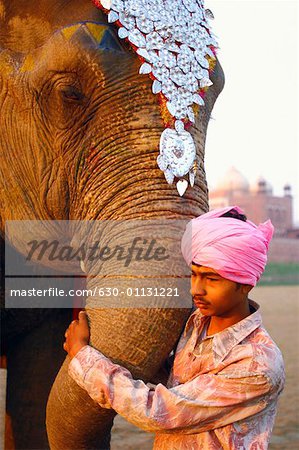 Profil de côté d'un jeune homme tenant une trompe d'éléphant
