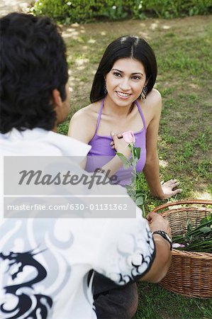 High angle view of a young man giving a young woman a rose
