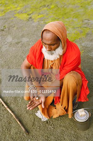 Erhöhte Ansicht eines Priesters reiben Tabak in seine Handfläche, Agra Uttar Pradesh, Indien