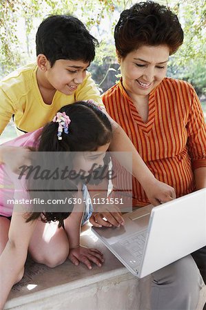 Nahaufnahme der eine reife Frau und ihre beiden Enkelkinder Blick auf einem laptop