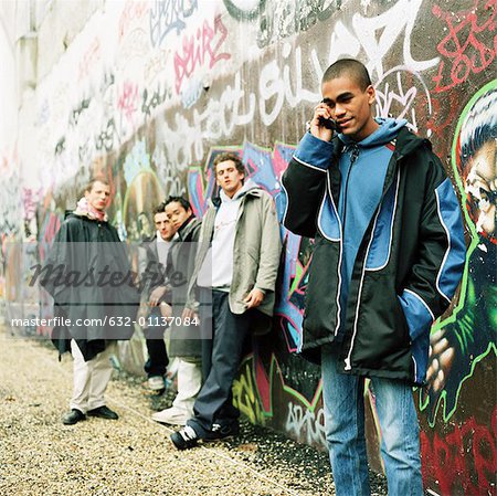 Fünf junge Männer vor Wand bedeckt in graffiti