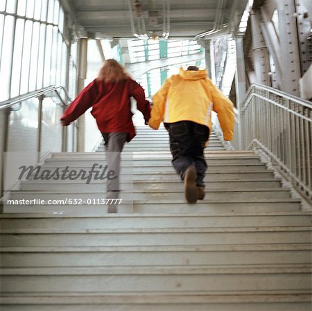 Jeunes, main dans la main et de remonter jusqu'à l'escalier dans la station de métro surélevé