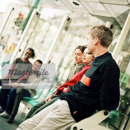 Young people sitting in bus station