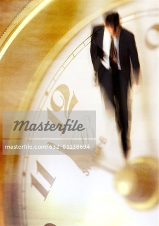 Businessman walking on clock, montage