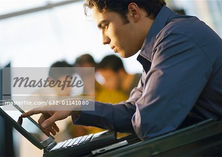 Man looking at laptop computer, side view