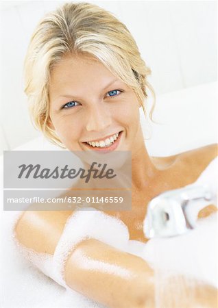 Femme dans la baignoire, souriant à la caméra, tête et épaules