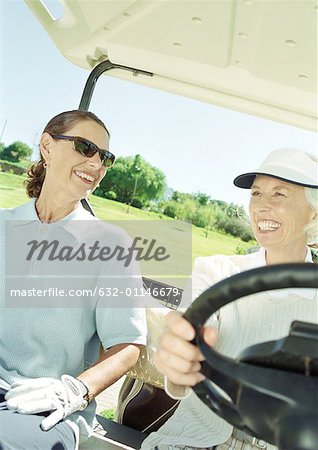 Deux femmes en voiturette de golf, mûres en gros plan