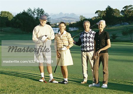 Four mature golfers on green, portrait