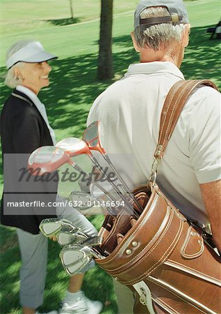 Deux golfeurs matures, un comptable clubs, vue arrière