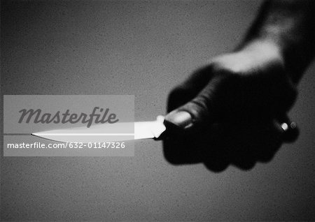 Hand holding knife, close-up, b&w