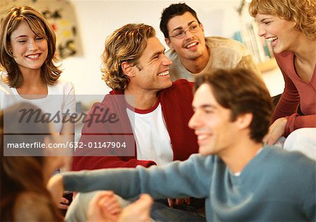 Group of young people sitting together, laughing, close-up