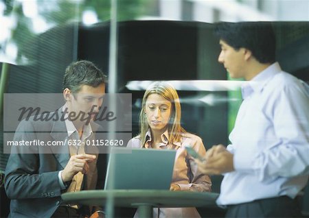 Businesspeopleng à table de café, à l'aide d'ordinateur portable