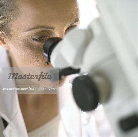 Doctor looking through microscope