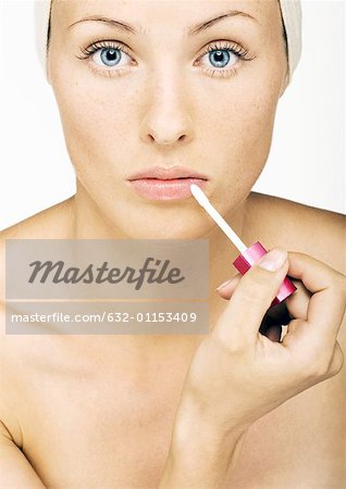 Woman applying lip gloss