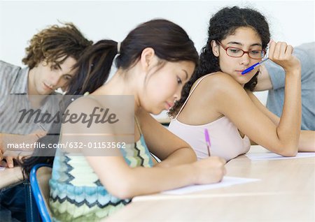 Students taking test in class, one student looking at another's paper