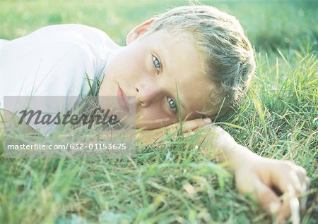 Garçon couché dans l'herbe