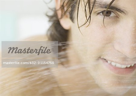 Man's face behind water spray