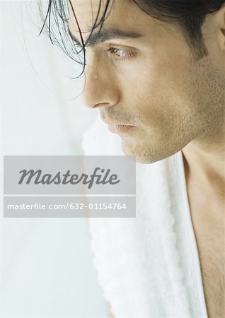 Homme avec les cheveux mouillés et serviette sur l'épaule