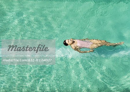 Woman swimming in pool, full length