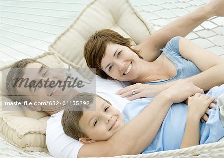 Family lying in hammock, smiling