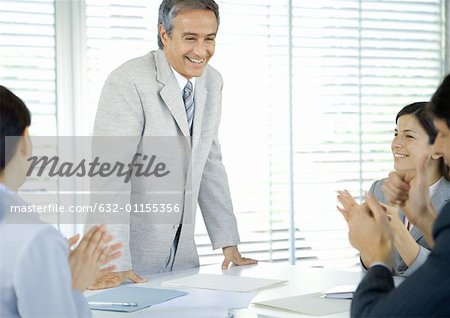 Business team applauding businessman