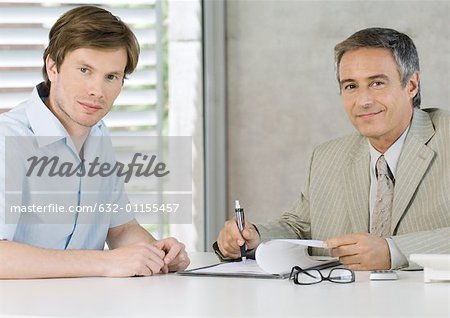 Jeune homme avec l'homme d'affaires mature, souriant à la caméra