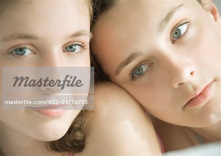 Two preteen girls, one with head on other's shoulder