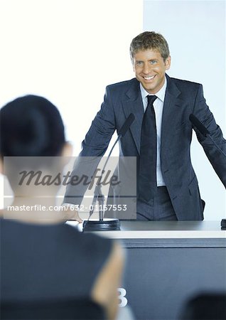 Homme debout à côté de microphone dans le séminaire