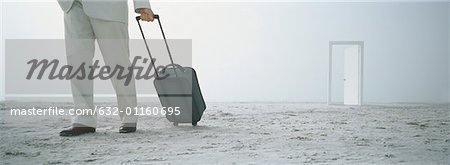 Kaufmann mit Koffer am Strand, Tür im Hintergrund