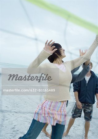 Friends playing beach volleyball