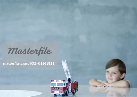 Boy looking at toy firetruck