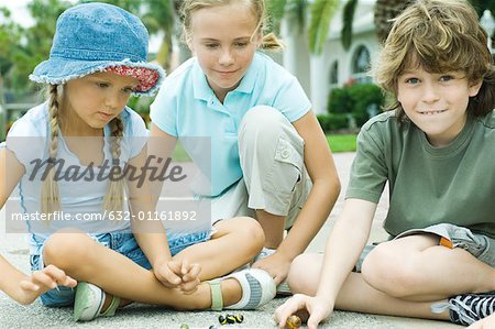 Children playing marbles in residential street