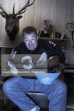 Man Watching Football Game on Television
