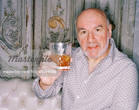 Portrait d'homme avec boisson sur canapé