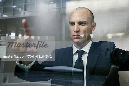 Businessman Pressing Finger Against Window