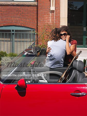 Couple Hugging Beside Car