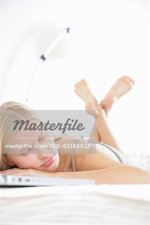 Frau im Bett, schlafen auf Laptop-Computer