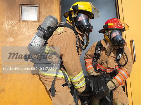 Feuerwehrleute tragen Dummy aus Smoky-Gebäude