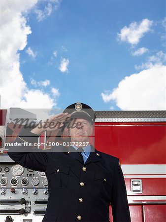 Chef des pompiers saluant par camion de pompier