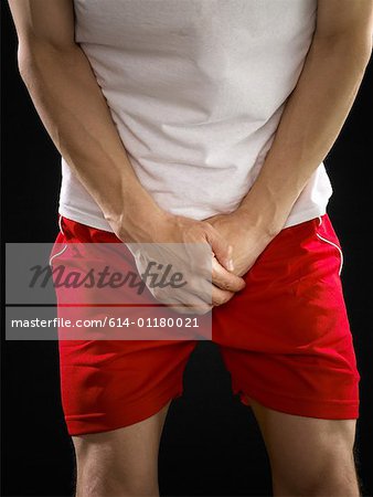 Man with hands covering his crotch