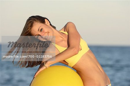 Fille à la plage avec le ballon d'exercice
