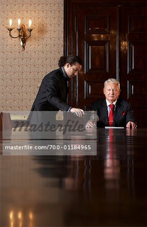 Servant Pouring Drink for Businessman