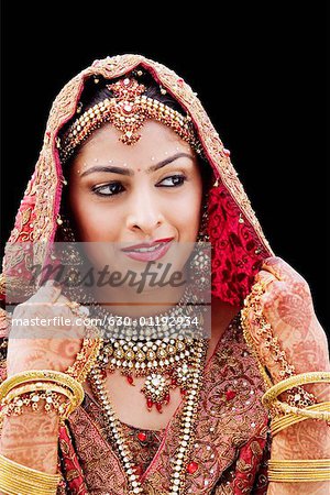 Close-up of a bride in a traditional wedding dress holding a veil