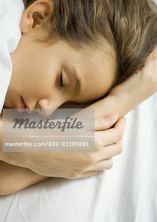 Girl sleeping, mother's hand on arm