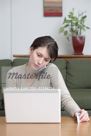 Woman Talking on Cell Phone, Using Laptop Computer